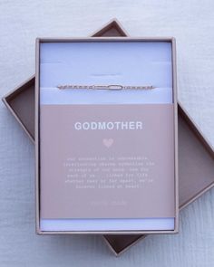 an open box containing a bracelet with the words godmother on it