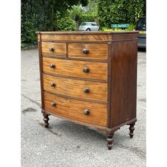 an old chest of drawers sitting in the middle of a parking lot