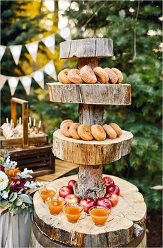 an outdoor dessert table with donuts and apples on it