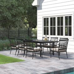 an outdoor dining table and chairs next to a pool