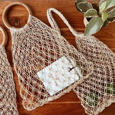 a bag and some scissors sitting on a table next to a potted plant with leaves