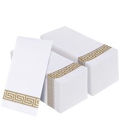 three white boxes with gold trims on them