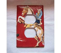 a red light switch cover with an image of a horse and rider on the letter b