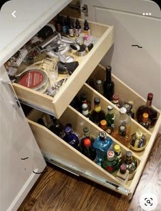 an open drawer in a kitchen filled with bottles