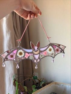 a bat hanging from the ceiling with flowers on it