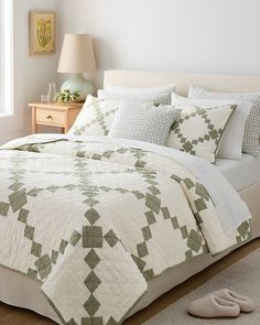 a bed with white and green bedspread in a bedroom