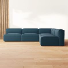 a blue couch sitting on top of a hard wood floor next to a white wall