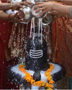 people are pouring water on the top of a cake