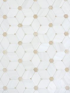 a white and gold tiled wall with hexagonal tiles