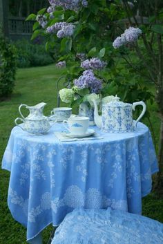 the table is set for two with tea cups and saucers in front of it