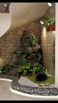 this is an image of a room with rocks and plants on the walls, along with a waterfall