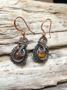 A 6mm round Tigers Eye bead that has been surrounded by woven copper wire and then suspended from copper ear wires. Artisan Copper Wire Drop Earrings, Wire Wrapped Teardrop Copper Jewelry, Copper Teardrop Wire Wrapped Jewelry, Adjustable Copper Wire Pierced Earrings, Bronze Wire Wrapped Round Jewelry, Adjustable Wire Wrapped Brown Earrings, Brown Wire Wrapped Dangle Earrings, Adjustable Brown Wire Wrapped Earrings, Bronze Wire Wrapped Teardrop Earrings