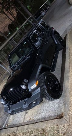 a black jeep is parked on the sidewalk