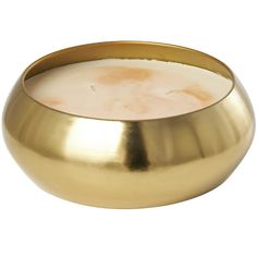 a gold bowl filled with liquid sitting on top of a white table