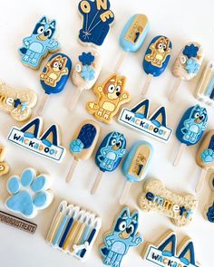 cookie pops decorated with blue and yellow icing, including cartoon characters on top of them