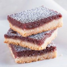 three pieces of cake sitting on top of a white plate covered in powdered sugar