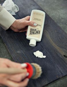 someone is using a bottle of toothpaste on a table