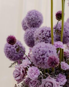 purple flowers are arranged in a vase on a table