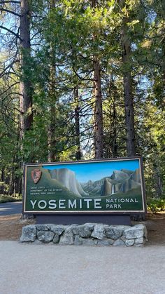 the yosemite national park sign is in front of some tall trees and rocks