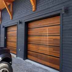 a black truck parked in front of a building with wooden garage doors on it's sides