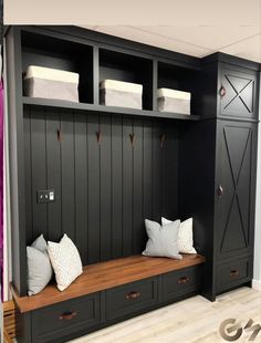 a room with some black cabinets and white pillows