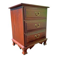 a wooden dresser with three drawers on one side and two brass pulls on the other