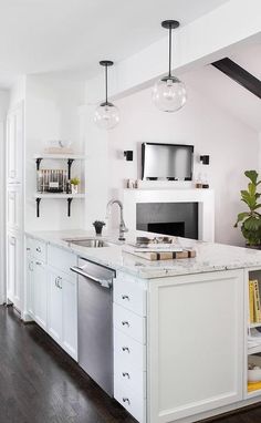 a kitchen with an oven, dishwasher and sink in the middle of it