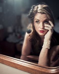 a woman with her hands on her face in front of a mirror