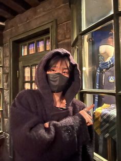 a woman wearing a face mask in front of a bookshelf filled with books