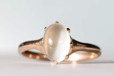 "Lovely antique natural moonstone ring in 10K yellow gold. This lovely ring features a gorgeous 9.5x7.2mm natural moonstone cabochon mounted in a lovely Edwardian yellow gold mount. The moonstone is held in place with eight prongs, all in excellent condition. Ring size 7 3/4 and easily sized up or down several sizes.  Please allow one week for sizing. One month layaway payment plans available for rings $500 and over. Approximate Age - Edwardian Gemstone(s) - natural moonstone  Metal - 10K yellow gold Weight - 2.06 grams Ring size - 7 3/4 Marks - 10K Makers Mark -  Comments -  Service & Sizing Information: If you require ring sizing or service, kindly follow the link below to add the appropriate service fee from the dropdown menu at the time of purchase. Also, please note your desired ring Opal Solitaire Ring, Moonstone Cabochon, Unusual Rings, Glass Rings, Lovely Ring, Moonstone Ring, Blue Topaz Ring, One Month, Pearl Ring