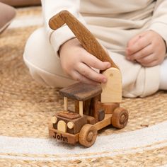 a child playing with a wooden toy truck