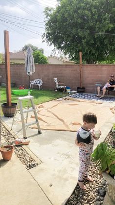 a little boy standing on top of a patio