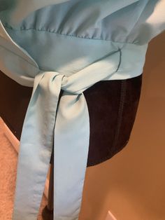 "Beautiful details on this flowy 1980s wrap style blouse. Light blue in color with gathers on the shoulders. Puffy sleeves, with fabric covered buttons and loops on the cuffs. Tie waist. Shoulder pads. There is a hook and eye closure on the bust - however the \"eye\" is a thread loop, it seems to do the job well. No manufacture tags. I estimate it to be a size small, around a size 6. It is shown and a size 6 dress warm with a 34 inch bust and a 26 inch waist. The bust measures 19 inches from arm Elegant Blue Blouse With Gathered Sleeves, Blue Fitted Blouse With Balloon Sleeves, Spring Blue Blouse With Gathered Sleeves, Chic Blue Blouse With Gathered Sleeves, Blue Blouse With Gathered Sleeves For Spring, Fitted Blue Blouse With Gathered Sleeves, Blue Fitted Top With Balloon Sleeves, Chic Blue Tops With Tie Sleeves, Blue Puff Sleeve Blouse With Gathered Sleeves