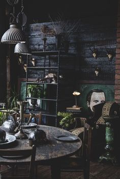 an old fashioned dining room table and chairs in front of a wall with deer heads on it