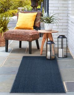 a chair sitting on top of a blue rug next to a table with a plant