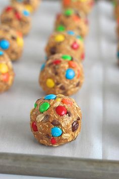 cookies with m & m's and candy are lined up on a baking sheet