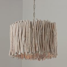 a light fixture made out of driftwood sticks hanging from a chandelier chain