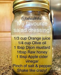 a jar filled with orange juice sitting on top of a counter