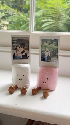 two marshmallows sitting next to each other on a window sill