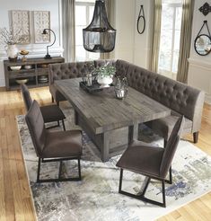 a dining room table with chairs and a bench in the middle of it on top of a rug