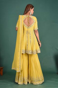 Beautiful yellow embroidered peplum sharara suit with dupatta. It is perfect for weddings and special occasions. Shop online from Pure Elegance. Designer Wear Peplum Sharara With Chikankari Embroidery, Yellow Chikankari Embroidered Sharara For Reception, Yellow Chikankari Embroidery Sharara For Reception, Designer Sharara With Chikankari Embroidery, Wedding Sharara With Chikankari Embroidery And Peplum Style, Designer Yellow Sharara With Chikankari Embroidery, Yellow Anarkali Set With Chikankari Embroidery For Reception, Yellow Chinon Palazzo Set With Dupatta, Traditional Peplum Sharara With Resham Embroidery