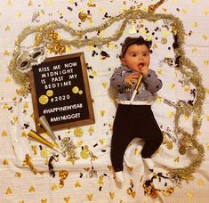 a baby doll laying on top of a bed with confetti and streamers