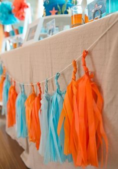 the table is set up with tissue tassels and decorations for an ocean themed baby shower