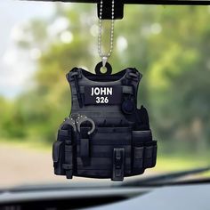 a police uniform ornament hanging from the dashboard of a car