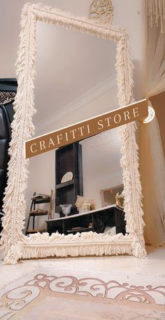 a mirror that is sitting on the floor in front of a table with a sign reading craftti store