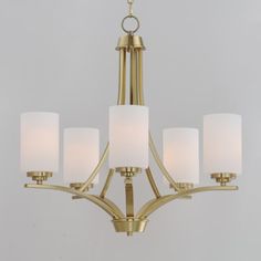 a chandelier with five lights hanging from it's center and white shades on the bottom