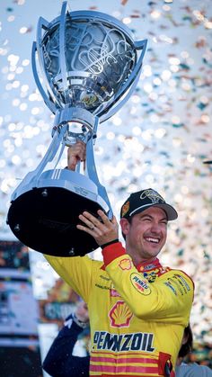 a man holding up a trophy in front of confetti