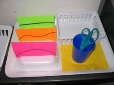 a plastic container with scissors and post it notes