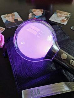 a magnifying glass sitting on top of a purple cloth next to some pictures