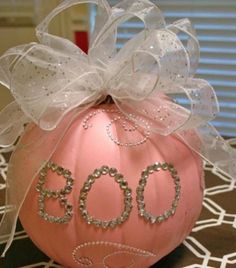 a pink pumpkin with the word boo painted on it's side and a bow